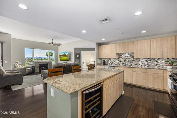 a kitchen with stainless steel appliances kitchen island granite countertop a refrigerator a stove a sink dishwasher with a dining table and chairs