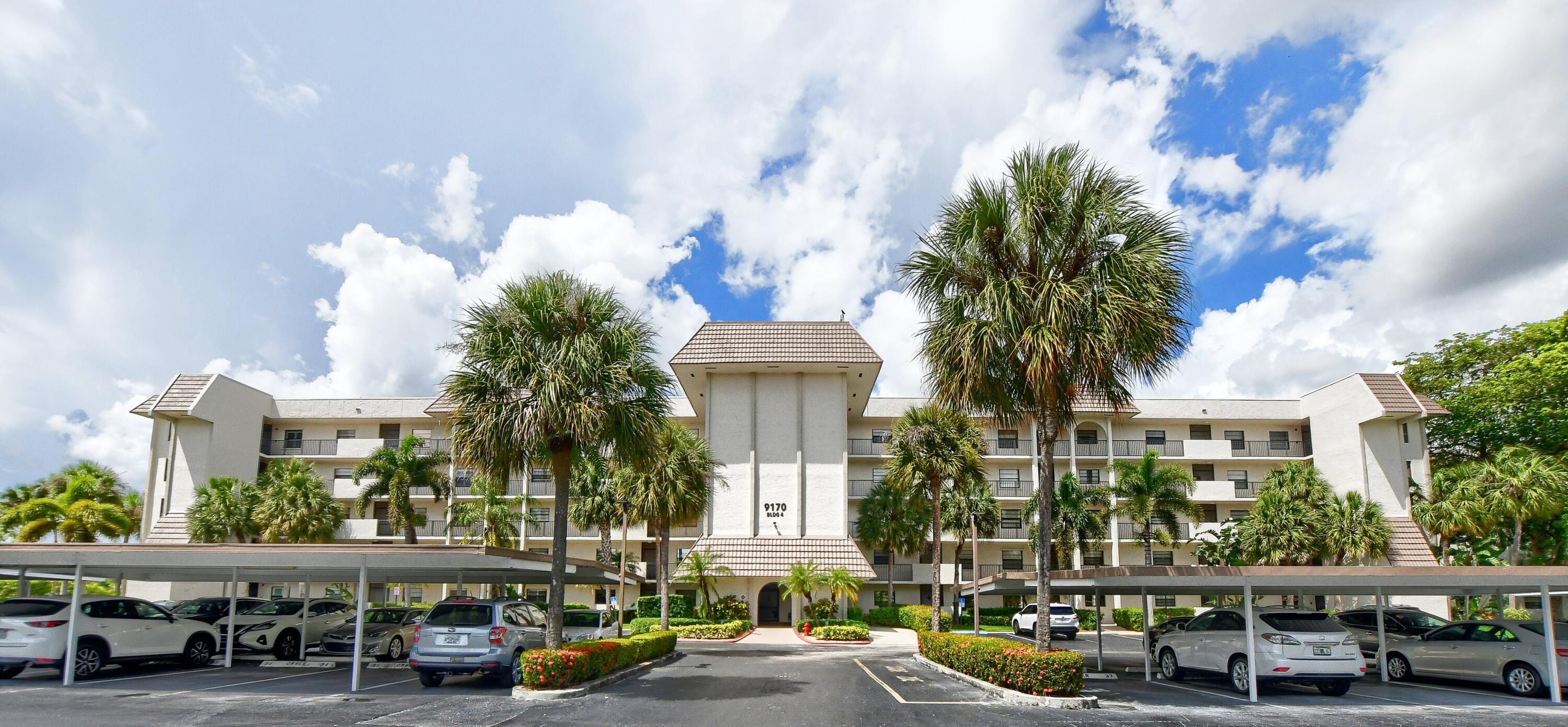 9170 Southwest 14th Street, Unit 4405 Boca Raton, FL 33428 - Photo 26 of 48 a front view of a building with lot of cars and trees