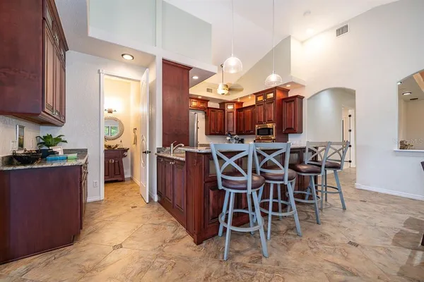 a kitchen with stainless steel appliances a table and chairs in it