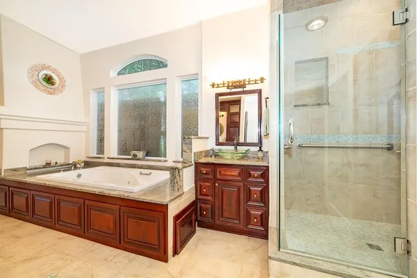 a spacious bathroom with a tub sink and mirror