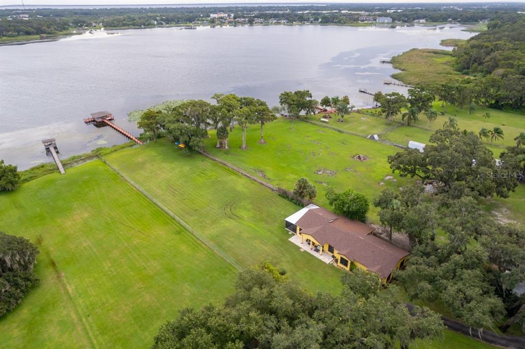 2339 Neptune Road, Unit A Kissimmee, FL 34744 - Photo 40 of 43 a view of a lake with a yard and trees in the background