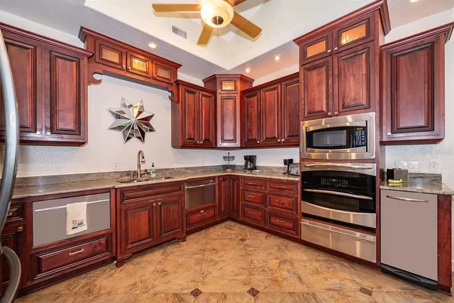 a kitchen with stainless steel appliances granite countertop a stove sink and cabinets