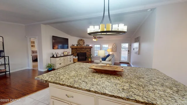 a view of a dining room with furniture a chandelier and wooden floor
