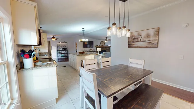 a dining room with furniture a chandelier and wooden floor
