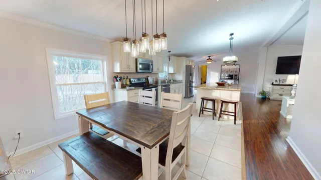 a living room with stainless steel appliances furniture and a wooden floor