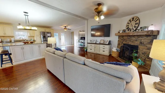 a living room with furniture a flat screen tv and kitchen view