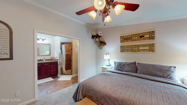 a bedroom with a bed and a flat tv screen on dresser