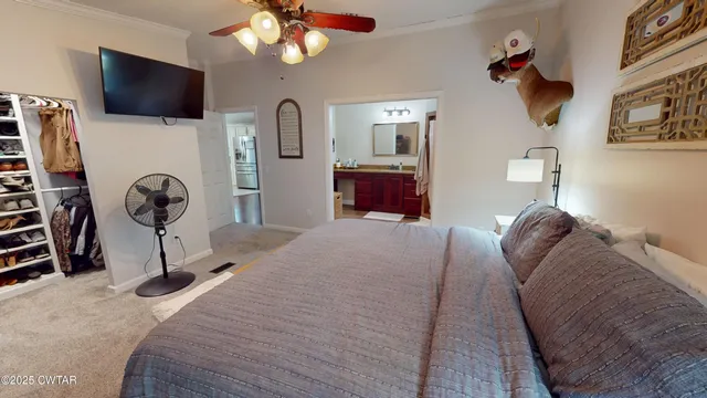 a bedroom with a large bed and a chandelier