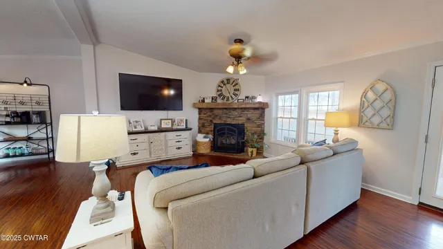a living room with furniture a flat screen tv and a fireplace