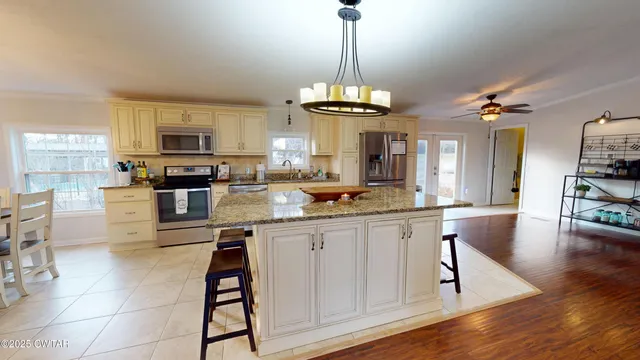 a kitchen with stainless steel appliances granite countertop a stove top oven a sink a counter space and cabinets