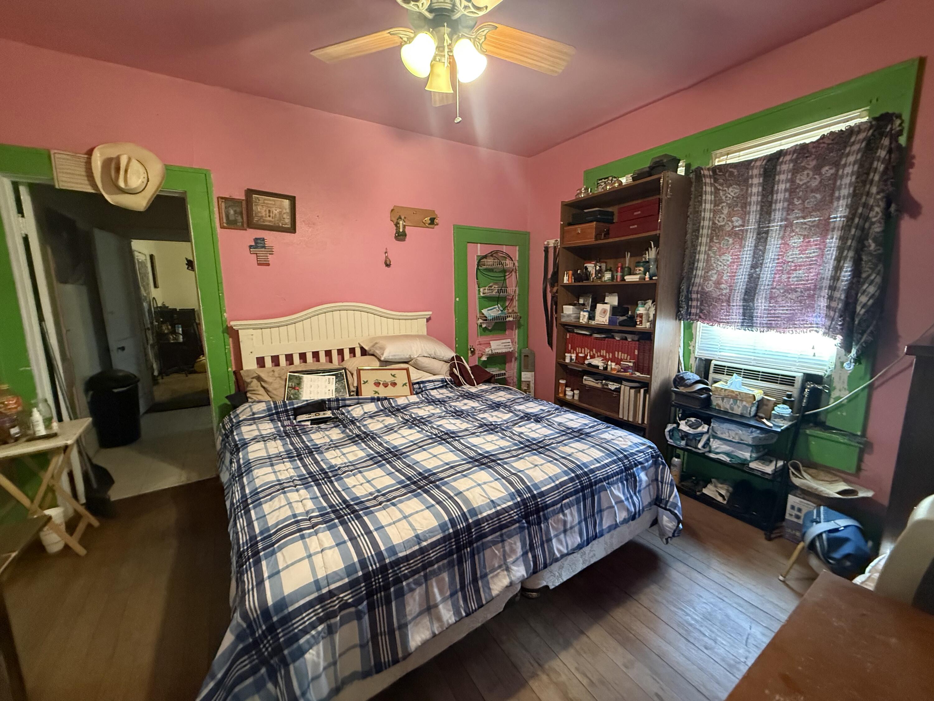 1924 14th Street Lubbock, TX 79401 - Photo 24 of 39 a bedroom with a bed a bookshelf and a flat tv screen