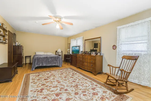 a living room with a couch and a dining table with wooden floor
