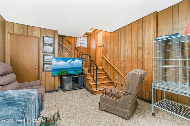 a living room with furniture a rug and white walls