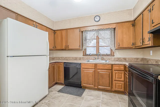 a kitchen with stainless steel appliances granite countertop a refrigerator sink and stove