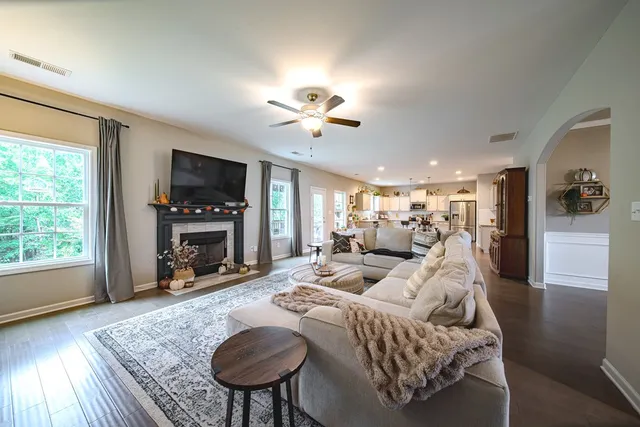 a living room with furniture a fireplace and a flat screen tv