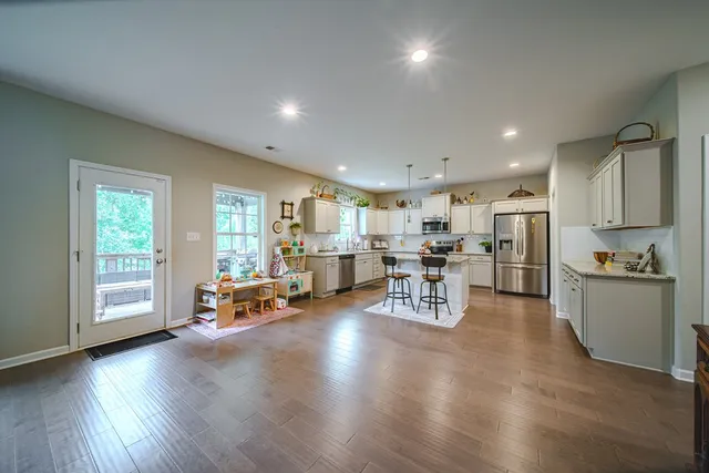 a kitchen with a sink a counter top space and living room view