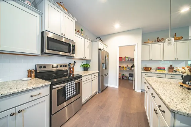 a kitchen with stainless steel appliances granite countertop a refrigerator stove microwave and sink
