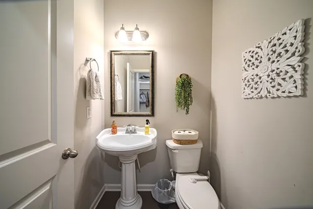 a bathroom with a toilet a sink and mirror