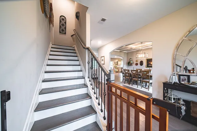 a view of staircase with lots of frames on wall and a window