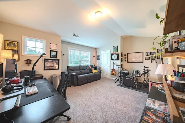 a living room with furniture a large window and gym equipment