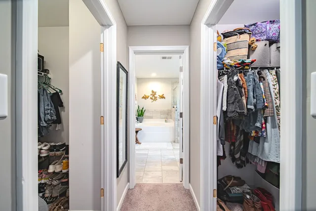 a view of a hallway with closet and a closet