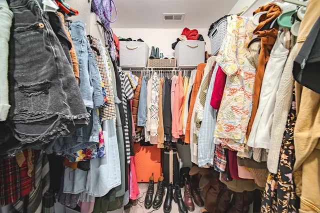 a view of walk in closet with clothes