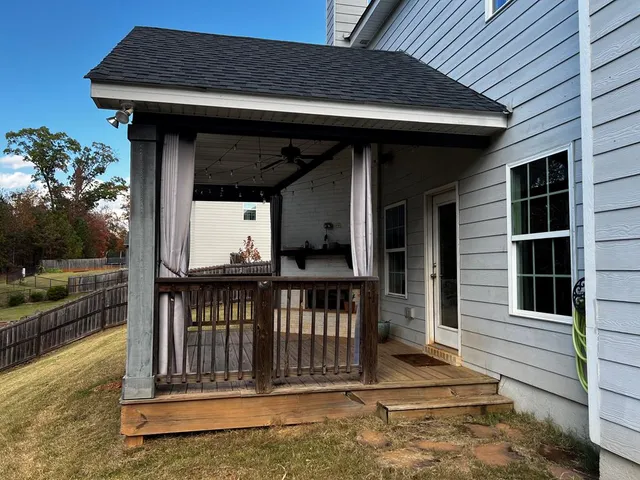 a view of a house with a wooden deck and a large window