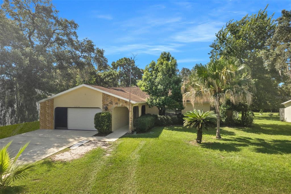 11206 Sheffield Road Spring Hill, FL 34608 - Photo 1 of 1 a front view of a house with a yard