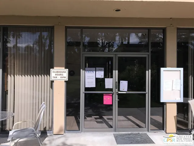 a dining room with wooden floor a chandelier a wooden table and chairs