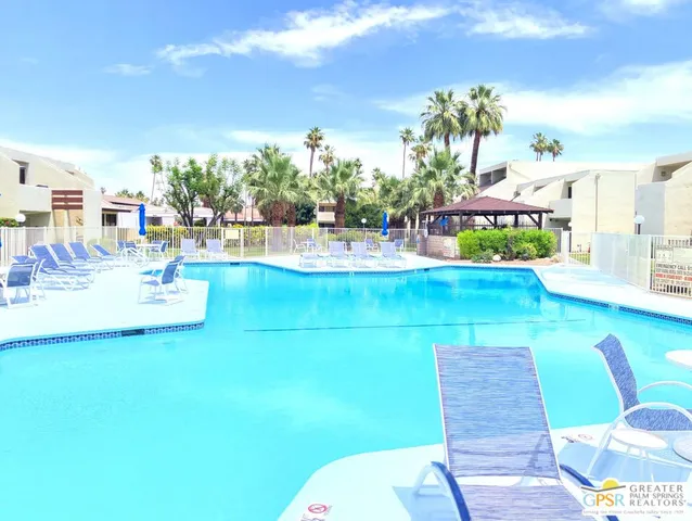a view of a house with a swimming pool and wooden fence