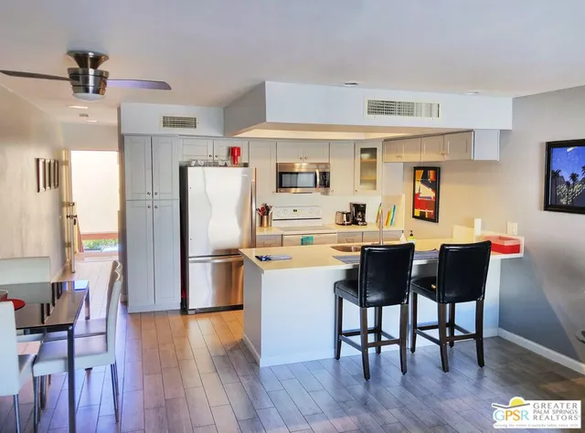 a kitchen with a dining table chairs refrigerator and cabinets