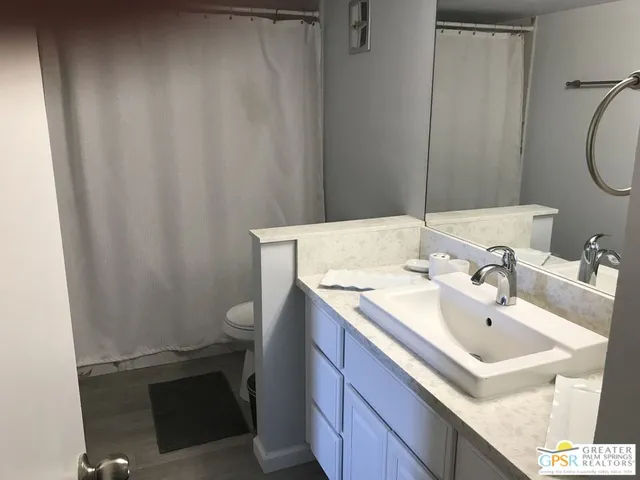 a bathroom with a sink a toilet and a mirror