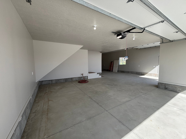 1184 West 3250 North Ogden, UT 84414 - Photo 64 of 69 Spacious garage featuring a concrete floor, painted walls, and an automatic garage door opener