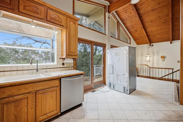 an aerial view of residential houses with outdoor space and trees