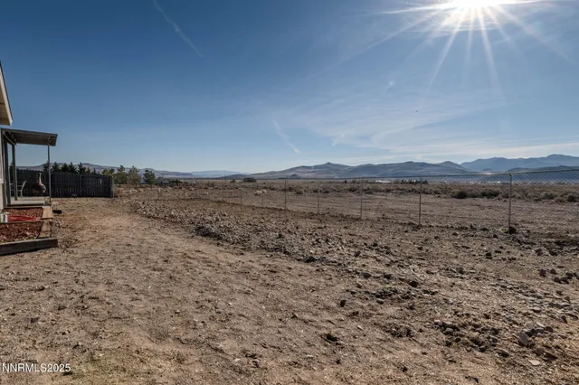 a view of a dry yard with mountain view
