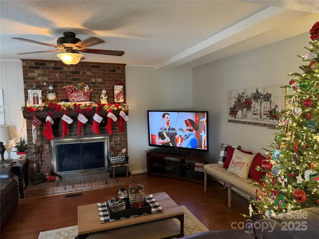 a living room with furniture a flat screen tv and a fireplace