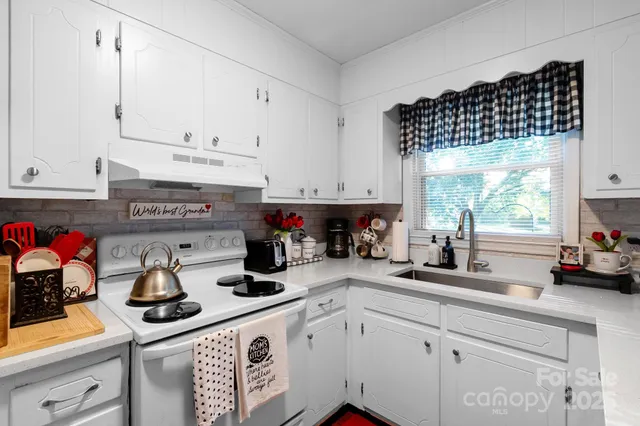 a kitchen with a sink a stove and cabinets