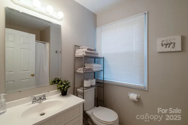 a bathroom with a sink mirror vanity and toilet