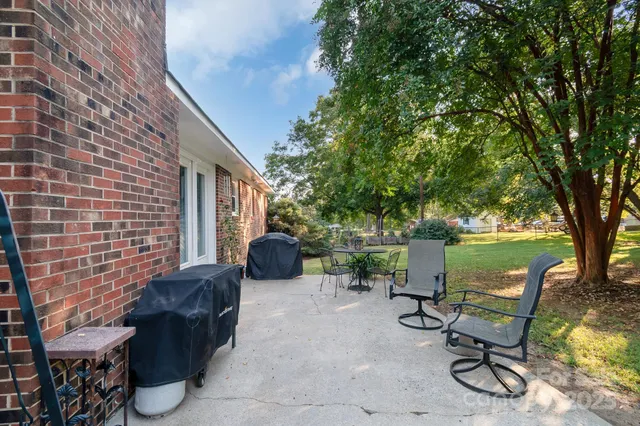 a view of backyard with outdoor seating and trees
