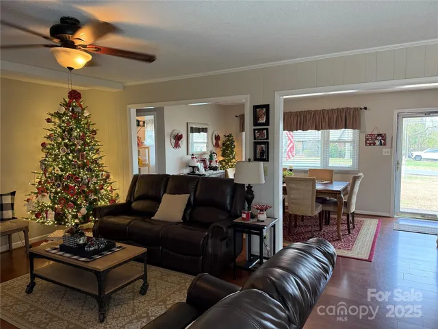 a living room with furniture a dining table a lamp and a large window
