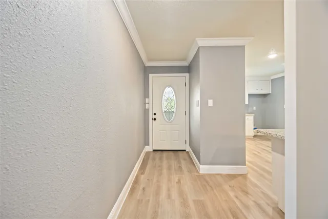 a view of a hallway with wooden floor and a bathroom