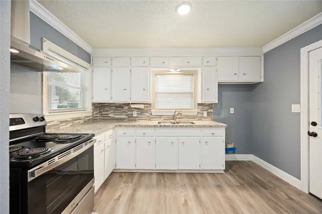 a kitchen with a sink stove and cabinets