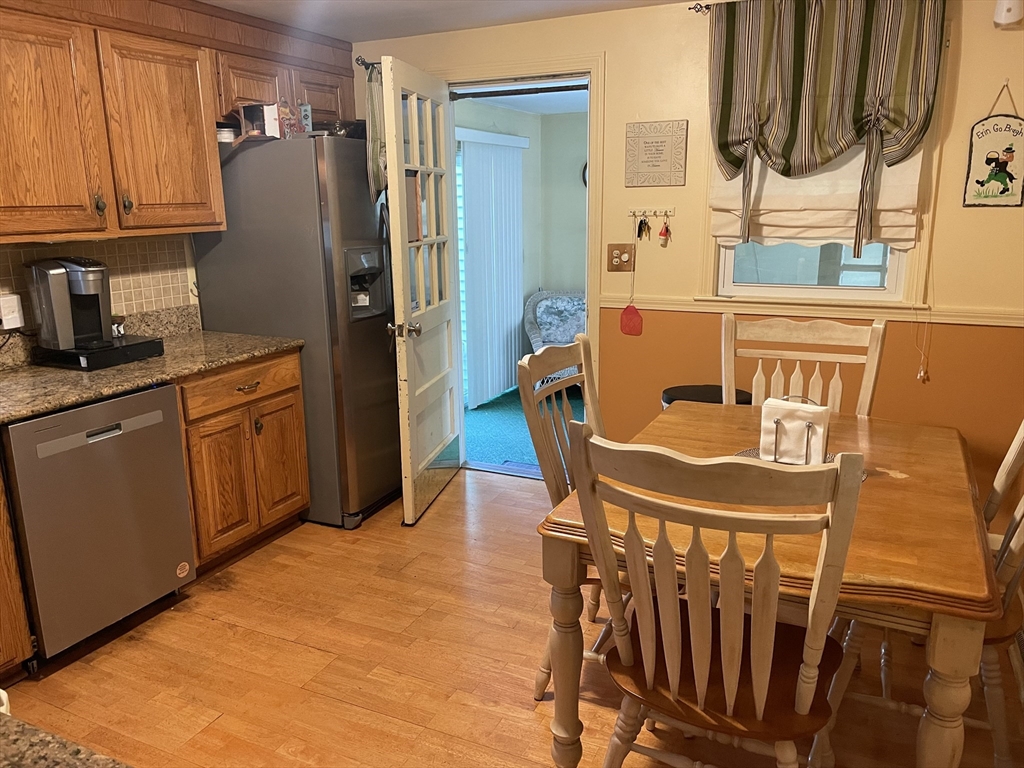 75 Lexington Road Billerica, MA 01821 - Photo 3 of 25 a kitchen with stainless steel appliances granite countertop a refrigerator a stove and a sink with wooden floor