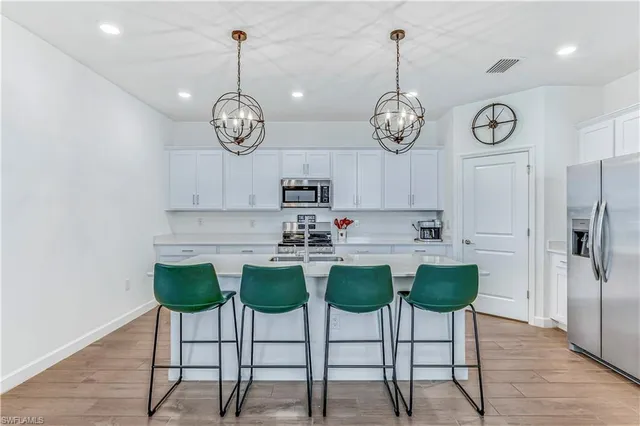 a view of dining table chairs wooden floor and a chandelier