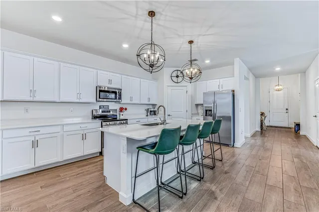 a kitchen with a dining table chairs refrigerator and cabinets