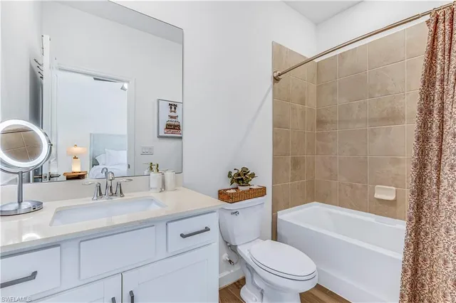 a bathroom with a sink a toilet a mirror a bathtub and shower