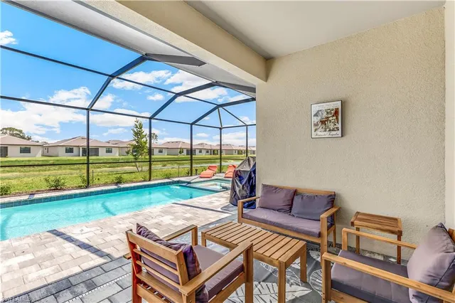 a living room with a couch a large dining table and a floor to ceiling window