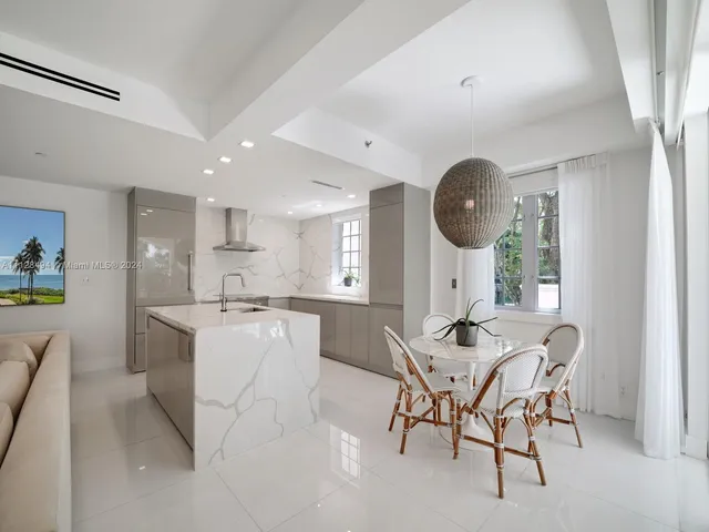 a kitchen with a dining table chairs and white cabinets