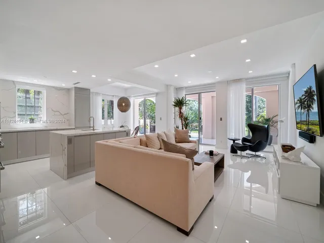 a living room with furniture kitchen and a large window