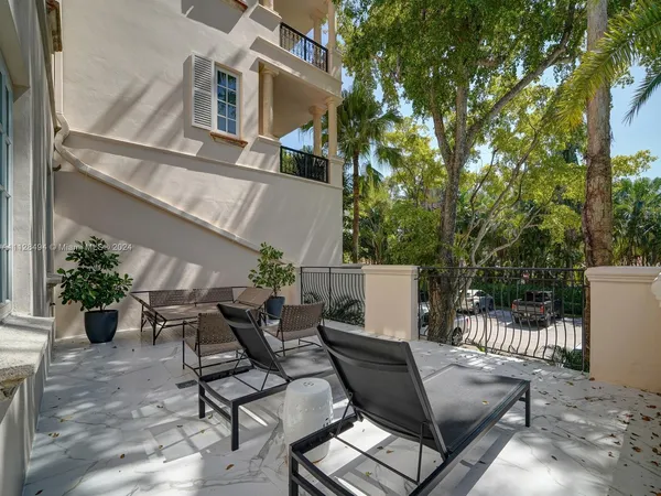 a view of a porch with chairs and potted plants